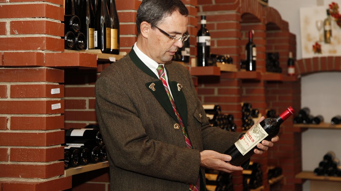 Herr Maurer im Weinkelle. Er begutachtet eine seiner Weinflaschen. | © Tourismusverband Oststeiermark
