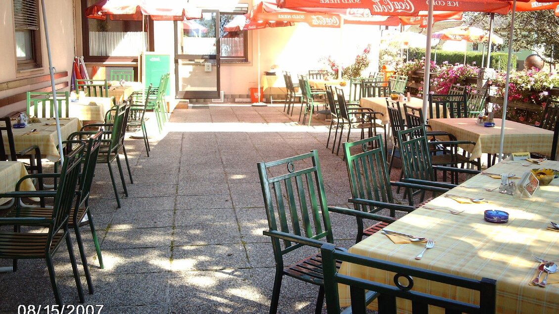 Ein gemütlicher Außenbereich mit Tischen und Stühlen. Über den Tischen sind Sonnenschirme aufgespannt, die Schutz vor der Sonne bieten. | © Gasthaus Walch