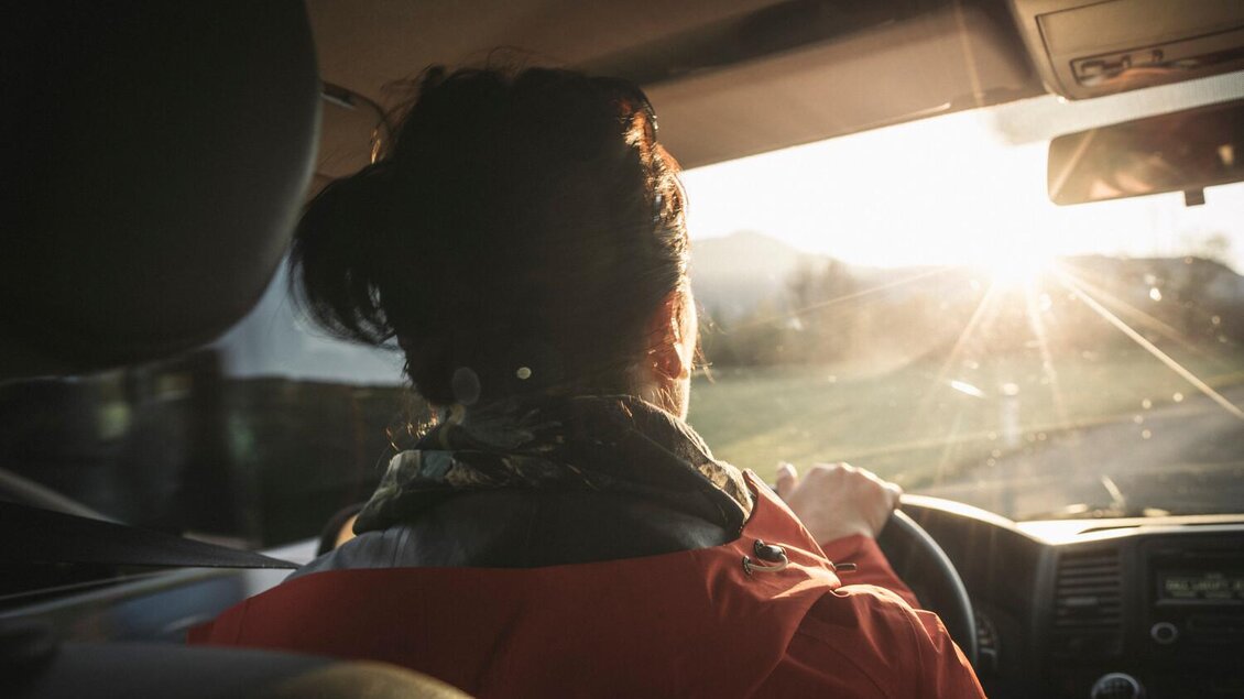 Eine Person fährt mit einem Auto in Richtung Sonnenuntergang. Die Szenerie zeigt eine entspannte und angenehme Atmosphäre. | © Stefan Leitner