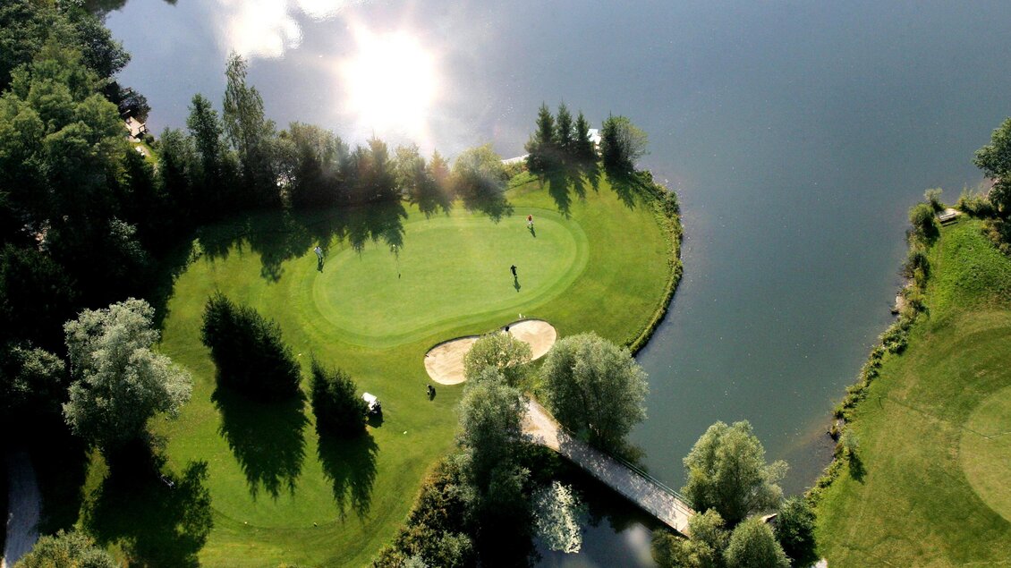 Luftaufnahme eines Golf-Grüns in Maria Lankowitz, umgeben von Wasser, mit Sandbunker und Bäumen in der Steiermark. | © GEPA Pictures