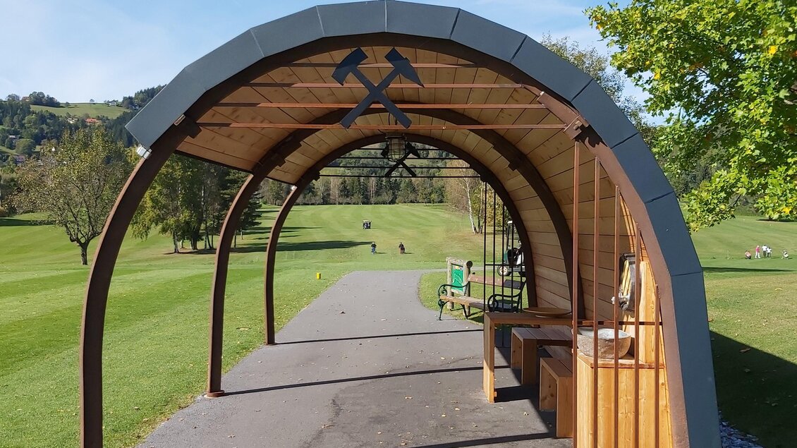 Überdachtes Starthaus am Golfplatz Maria Lankowitz mit Holzkonstruktion und Blick auf die Driving Range. | © Manuel Wiedner