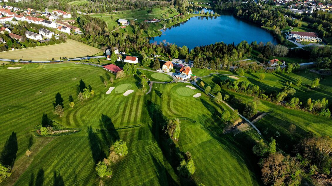 Luftaufnahme der Fairways und Grüns des Golfclubs Erzherzog Johann mit See im Hintergrund in Maria Lankowitz. | © Golferlebnis Steiermark - Manuel Wiedner