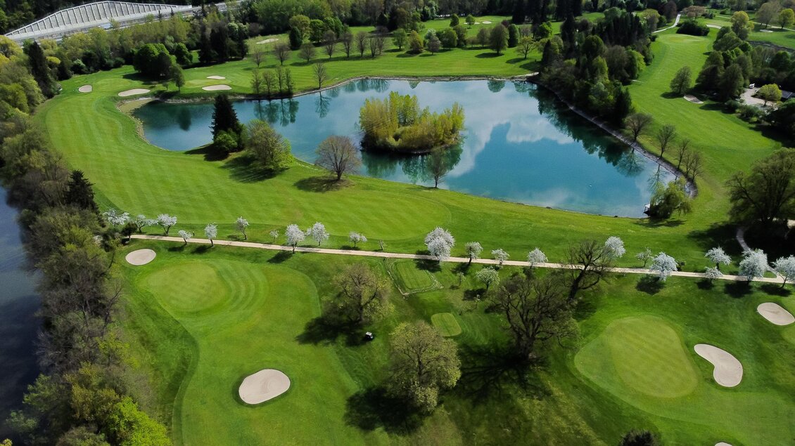 Luftaufnahme des Golfclubs Murhof mit Fairways, Blütenallee und großem See mit Insel im Zentrum der Anlage in Frohnleiten.  | © Golferlebnis Steiermark - Manuel Wiedner