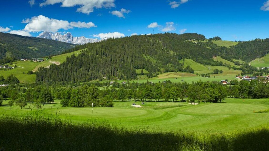 Eine schöne Landschaft mit grünen Wiesen und Hügeln. Im Hintergrund sind schneebedeckte Berge und ein klarer blauer Himmel zu sehen. | © Golfclub Radstadt