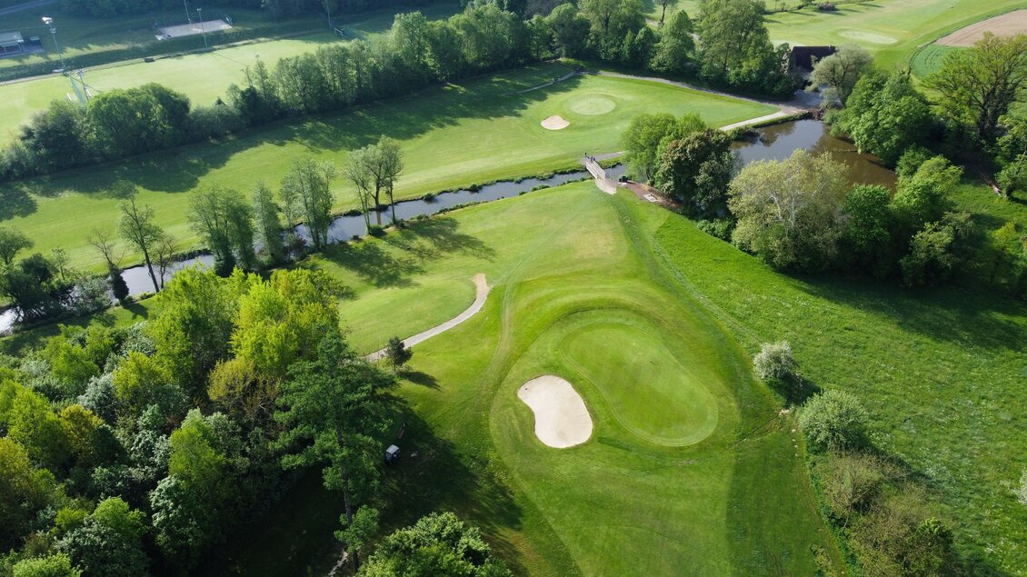 Luftaufnahme eines Greens mit Sandbunker, Bachlauf und Brücke auf der Golfanlage des Golfclubs Thalersee in Thal.  | © Golferlebnis Steiermark - Manuel Wiedner