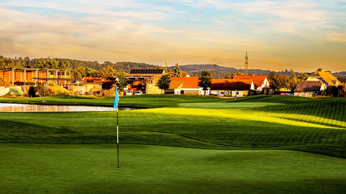 Green mit Fahne, Wasserhindernis und sanftem Abendlicht im Golfclub Grazer MurAuen in Gössendorf.  | © Golferlebnis Steiermark - Manuel Wiedner
