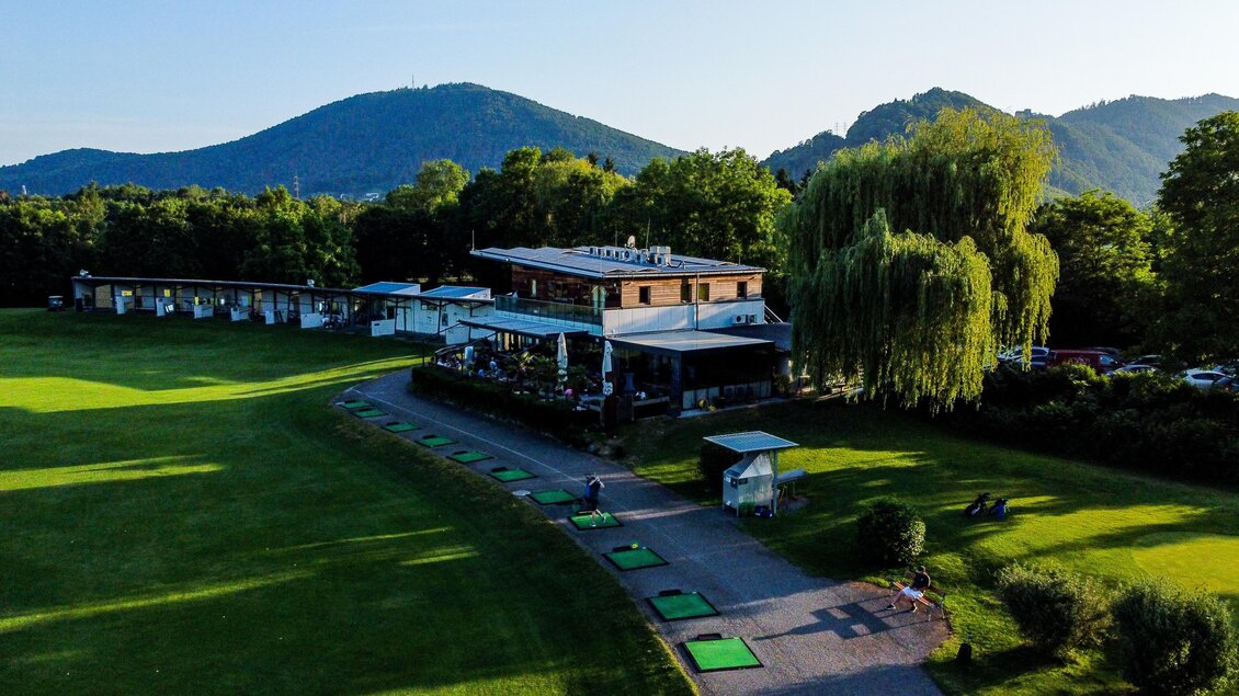 Luftaufnahme des Golfclubs Andritz mit Clubhaus, Driving Range und Golfspielern an den Abschlagplätzen in Graz.  | © Golferlebnis Steiermark - Manuel Wiedner