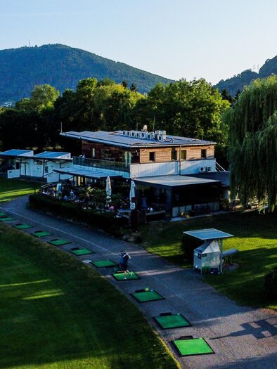 Luftaufnahme des Golfclubs Andritz mit Clubhaus, Driving Range und Golfspielern an den Abschlagplätzen in Graz.  | © Golferlebnis Steiermark - Manuel Wiedner