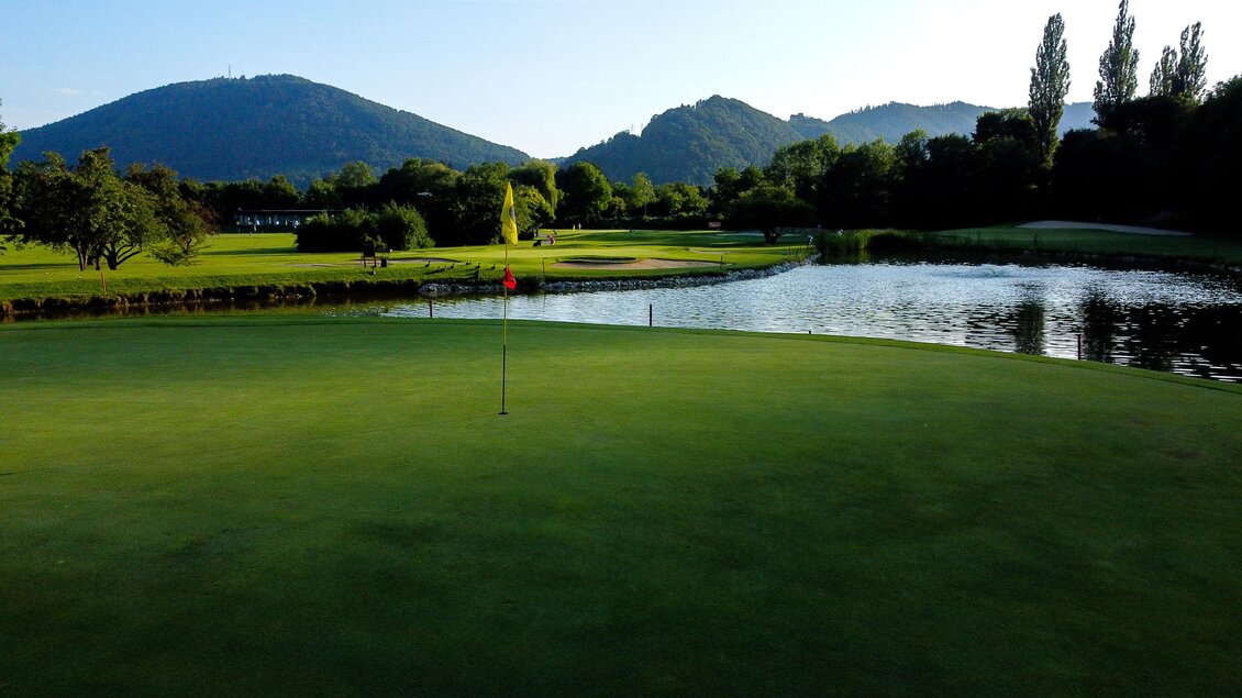 Blick über ein Green mit Fahne und Wasserhindernis im Golfclub Andritz in Graz. | © Golferlebnis Steiermark - Manuel Wiedner