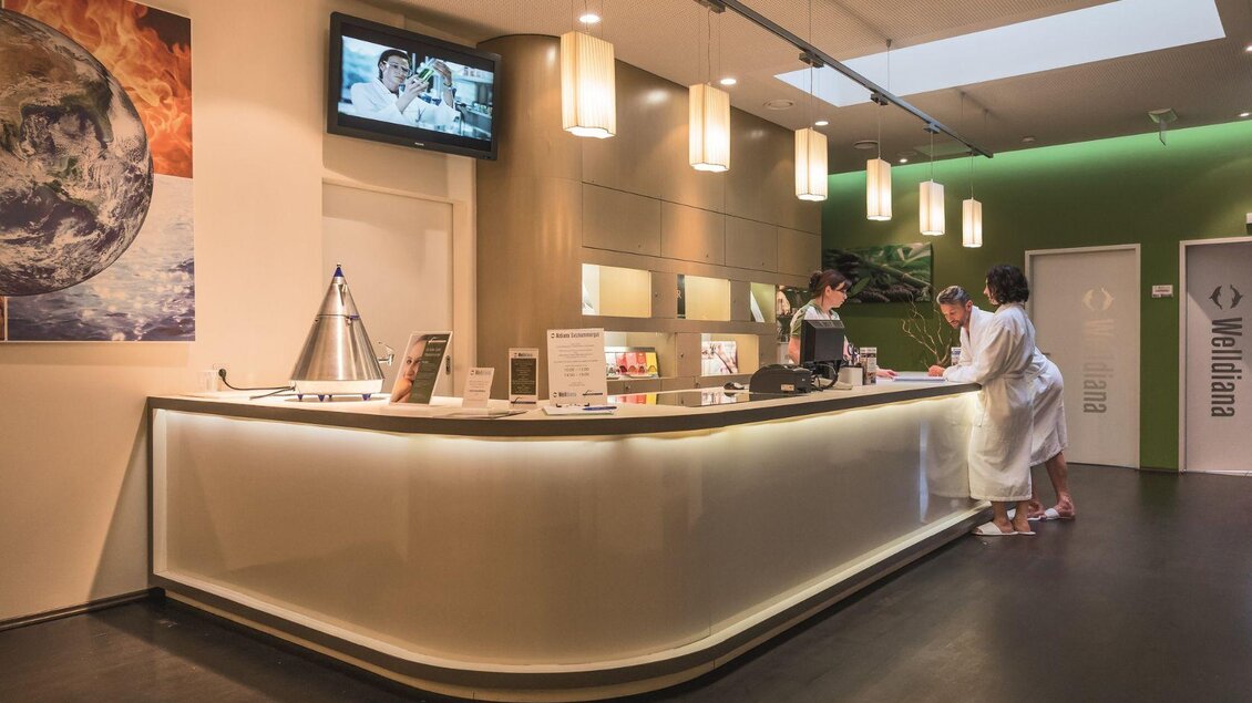 Im eleganten Empfangsbereich der GrimmingTherme begrüßt das freundliche Servicepersonal die Gäste und hilft ihnen gerne weiter. | © GrimmingTherme / P.Aldag