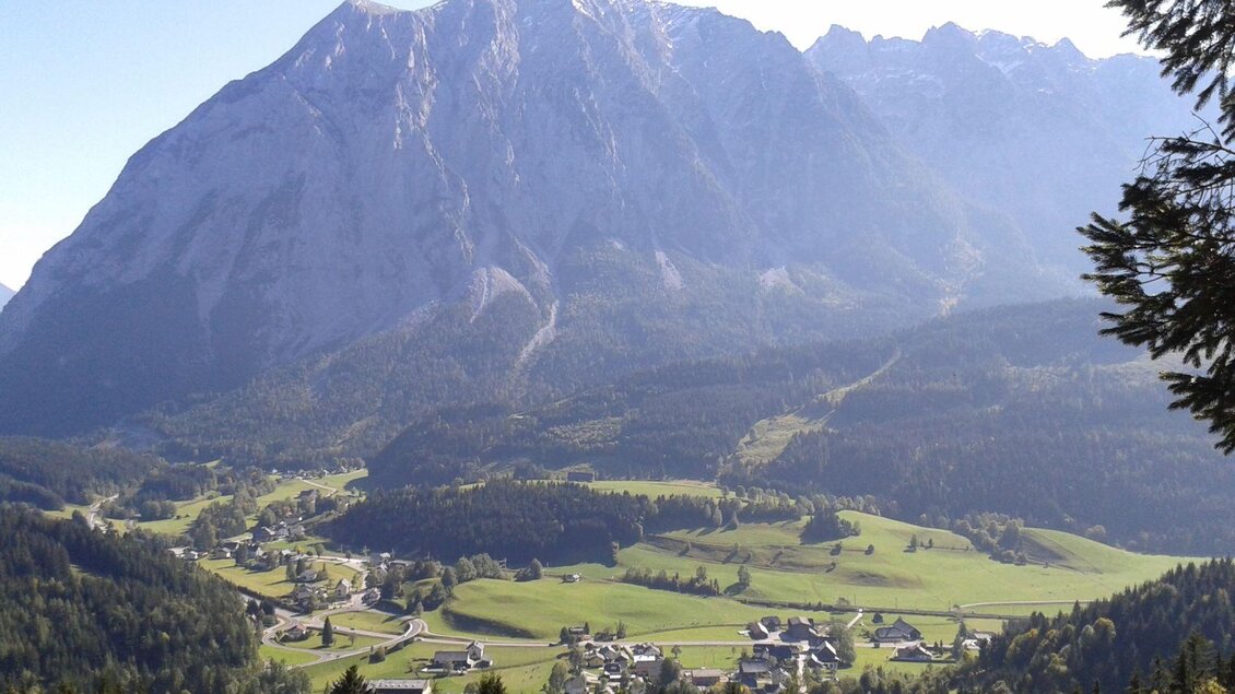 <p>Der Hausberg von Tauplitz, der Grimming ist ein eindrucksvoller Berg mit mehreren hohen Gipfeln. Im Vordergrund ist ein malerisches Dorf in einem grünen Tal zu sehen.</p> | © TVB Ausseerland Salzkammergut
