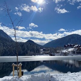 Die winterliche Landschaft von Grundlsee mit viel Schnee und dem angefrorenen Grundlsee. Im Hintergrund sind die Berge des Ausseerland Salzkammergutes unter einem klaren blauen Himmel zu sehen. | © TVB Ausseerland