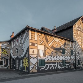 Bemalte Fassade der Haindl-Mühle in Kalsdorf bei Graz mit Mühlrad und Symbolen | © ee photograph - Elena Egger