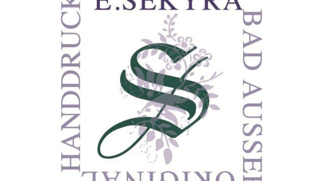 Das Logo von Handdrucke Sekyra in Bad Aussee mit einem gedruckten Muster im Hintergrund. | © Handdrucke Sekyra-Helge Kirchberger