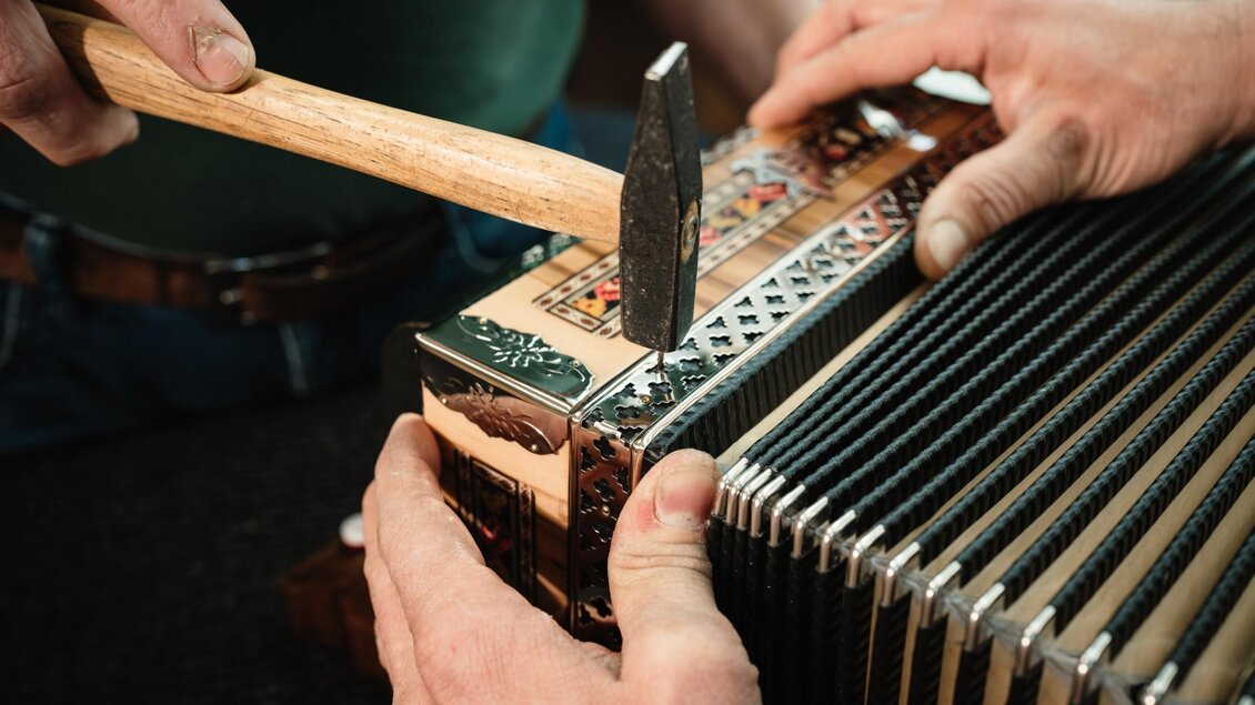 Mit Hammer und Hand werden letzte Arbeiten an einer Steirischen Harmonika von Harmonika Parz ausgeführt. | © Bernd Grosseck