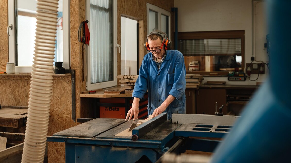 Ein Handwerker schneidet an einer Tischkreissäge Holzteile für eine Steirische Harmonika von Harmonika Parz zu. | © Bernd Grosseck