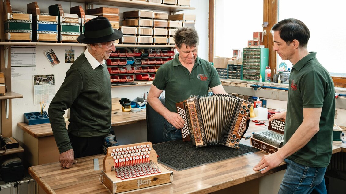 Drei Handwerker stimmen und prüfen eine fertig montierte Steirische Harmonika in der Werkstatt von Harmonika Parz. | © Bernd Grosseck