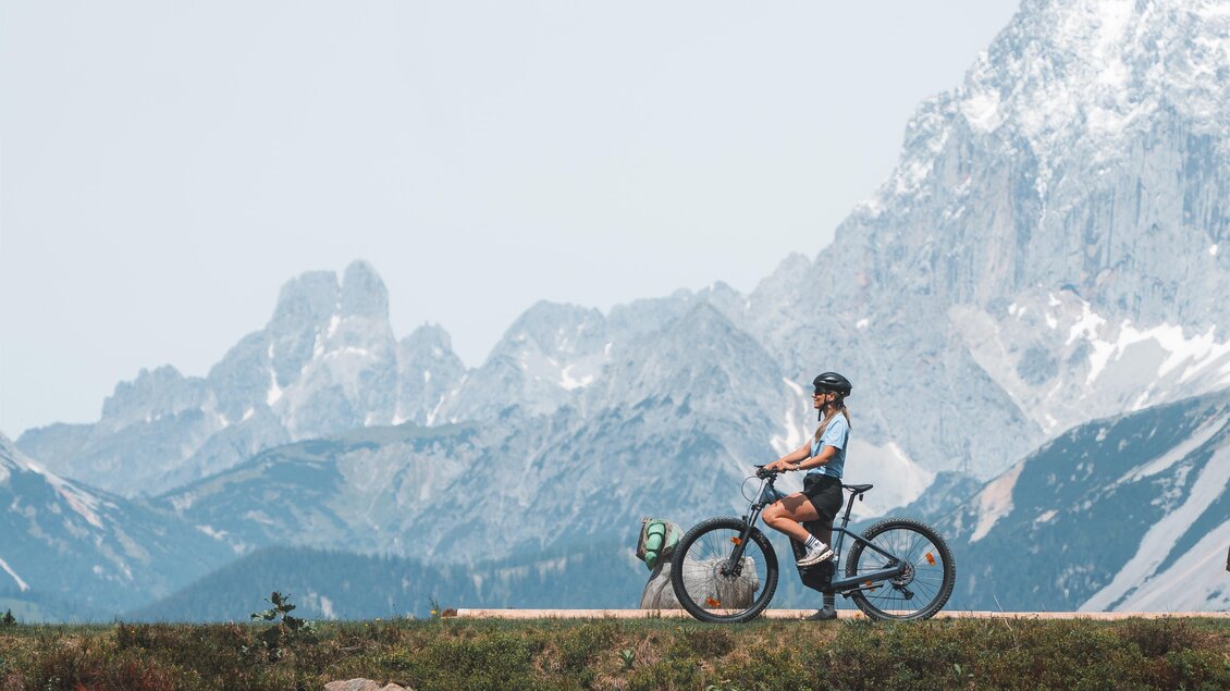 Radfahrerin genießt den Ausblick auf das Dachsteinmassiv. | © Hauser Kaibling