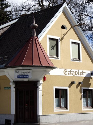 A cozy building with a red roof and yellow facade.  
On the wall, there is the inscription "Eckwirt" and there are a few windows of various sizes. | © TV  Region Graz - Lunghammer