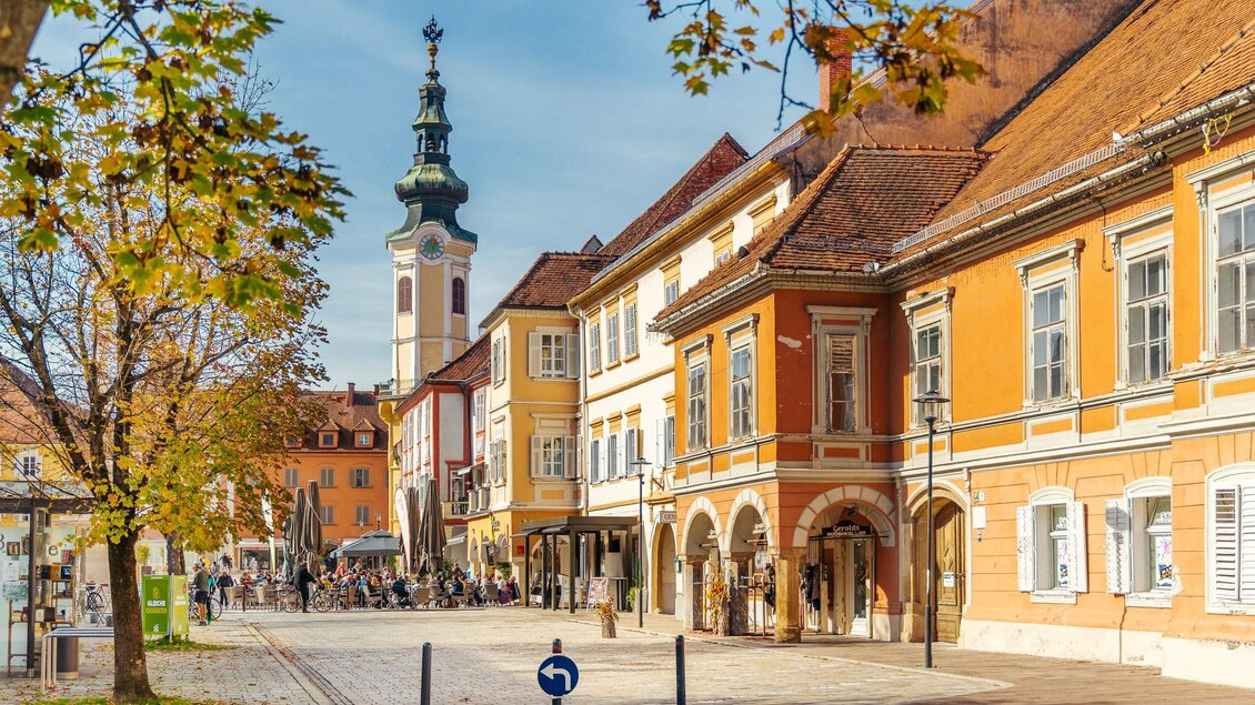 Historische Altstadt von Bad Radkersburg mit farbigen Häuserfassaden, Kirchturm, Straßencafés und herbstlich gefärbten Bäumen an einem sonnigen Tag. | © Zehnerhaus Bad Radkersburg