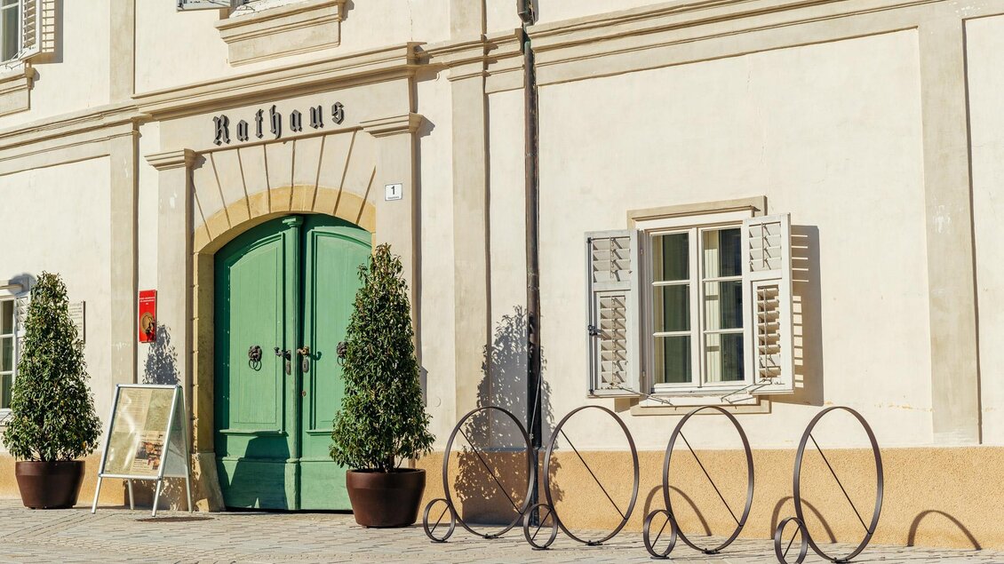 Historisches Rathaus in der Altstadt von Bad Radkersburg mit grüner Eingangstür, klassischer Fassade und Fahrradständern im Stadtzentrum. | © Zehnerhaus Bad Radkersburg