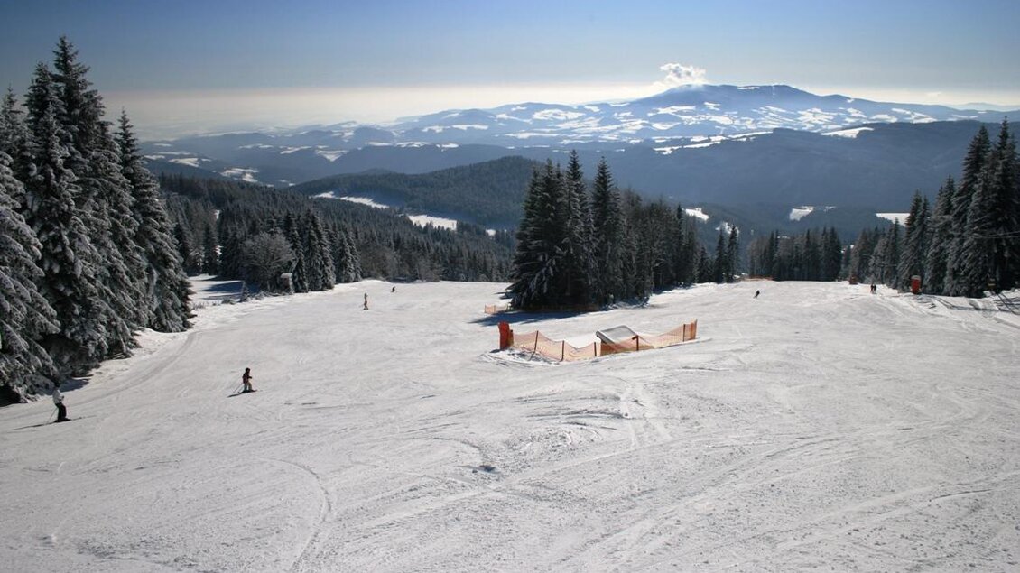 Zu sehen ist die Skipiste am Hochwechsel mit Ausblick auf die Winterlandschaft rundum. | © Andreas Schwengerer