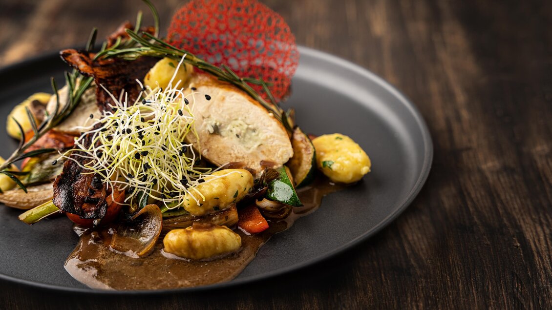 <p>Ein raffiniert angerichtetes Gericht mit Gnocchi, Gemüse und einer reichen Sauce, garniert mit frischen Kräutern und einem knusprigen Chip in der Hofkuchl in Semriach.</p> | © Wolfgang Hummer
