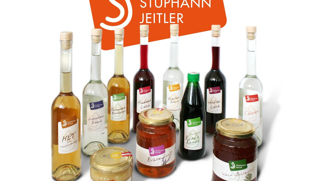 Eine Auswahl an Flaschen und Gläsern mit verschiedenen Getränken und Aufstrichen der Marke "Stuphann Jeitler". Die Produkte sind ansprechend präsentiert und zeigen eine Vielfalt an Farben und Formen. | © Familie Stuphann-Jeitler