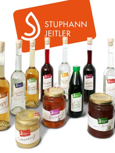 Eine Auswahl an Flaschen und Gläsern mit verschiedenen Getränken und Aufstrichen der Marke "Stuphann Jeitler". Die Produkte sind ansprechend präsentiert und zeigen eine Vielfalt an Farben und Formen. | © Familie Stuphann-Jeitler