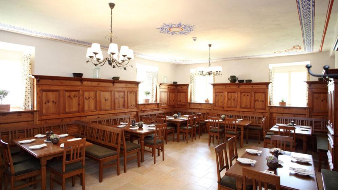 Ein gemütliches Restaurant mit Holzmöbeln und mehreren Tischen. Die Wände sind hell gestrichen und es gibt natürliche Lichtquellen durch Fenster. | © Tauroa GmbH