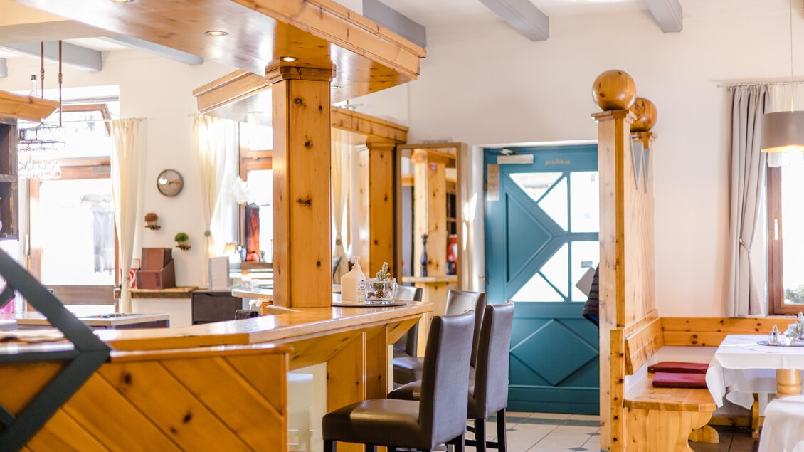 Ein gemütliches Restaurant mit Holzelementen und einem freundlichen Ambiente. Die Tür ist in einem schönen Blau gehalten, was dem Raum Charakter verleiht. | © Römerhof