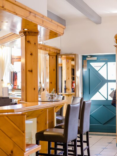 Ein gemütliches Restaurant mit Holzelementen und einem freundlichen Ambiente. Die Tür ist in einem schönen Blau gehalten, was dem Raum Charakter verleiht. | © Römerhof