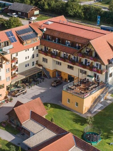 Ein modernes Hotel mit einem großzügigen Außenbereich und gemütlichen Balkonen. Umgeben von Naturlandschaft bietet es einen einladenden Eindruck. | © Hotel Angerer-Hof