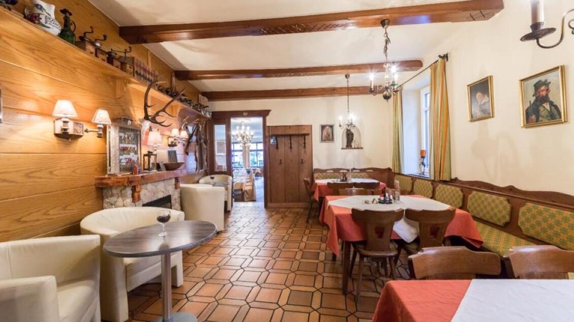 Ein gemütliches Restaurant mit Holzwänden und traditioneller Einrichtung. Es gibt Tischdecken in Rot und eine warme, einladende Atmosphäre. | © CORDES-Werbeconsulting GmbH