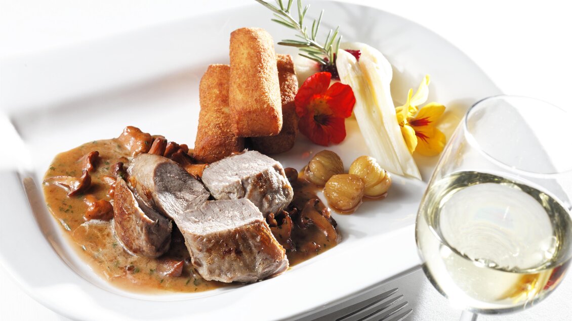 Ein anspruchsvolles Gericht mit zartem Fleisch, cremiger Sauce, Kroketten und frischen Beilagen. Dazu ein Glas Weißwein. | © Bernhard Bergmann