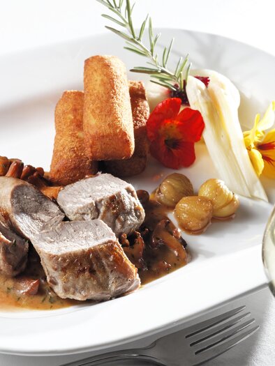 Ein anspruchsvolles Gericht mit zartem Fleisch, cremiger Sauce, Kroketten und frischen Beilagen. Dazu ein Glas Weißwein. | © Bernhard Bergmann