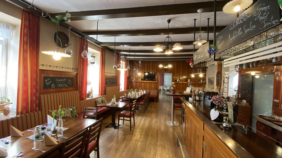 Ein gemütliches Restaurant mit Holztischen und -stühlen. Die Wände sind warm dekoriert und es gibt eine Bar im hinteren Bereich. | © Hotel & Wirtshaus Hödl-Kaplan