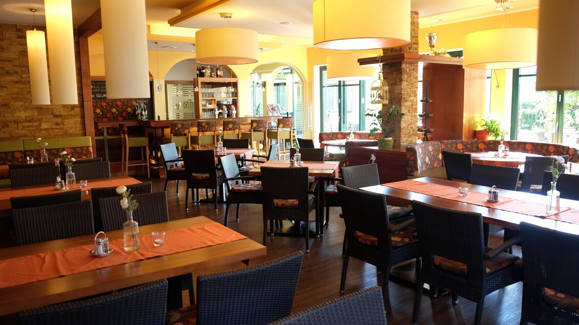 Ein gemütliches Restaurant mit Holztischen und schwarzen Stühlen. Die Räume sind hell erleuchtet und bieten eine einladende Atmosphäre. | © Hotel-Restaurant Neuhold