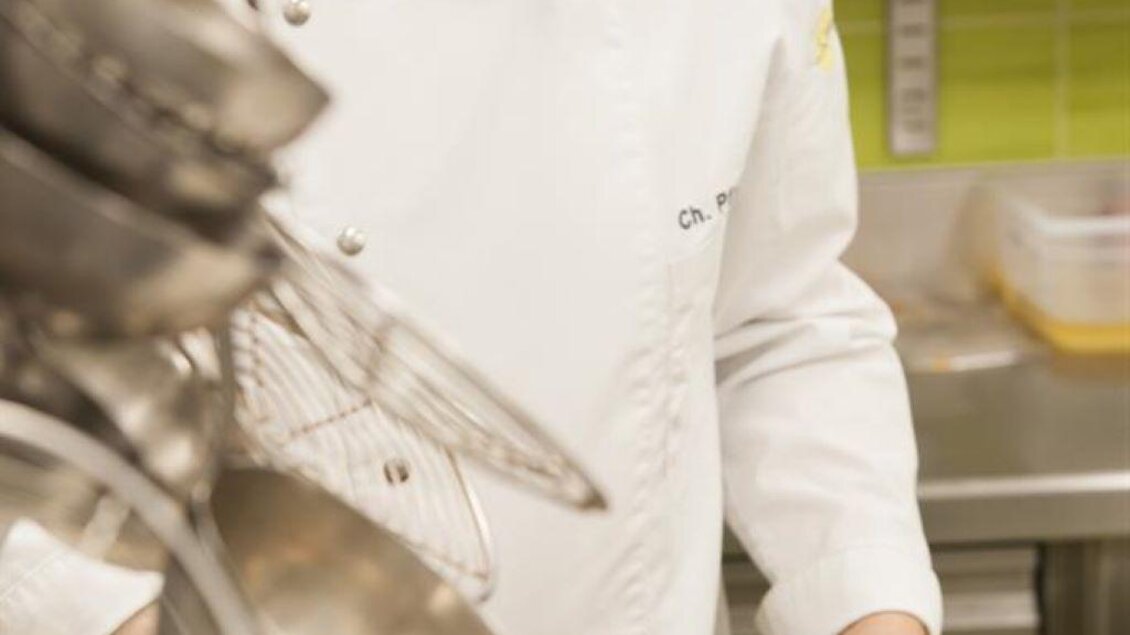 Ein Koch bereitet eine köstliche Speise in einer modernen Küche zu. Er rührt mit einem Löffel in einem Topf. | © Hotel-Restaurant Staribacher