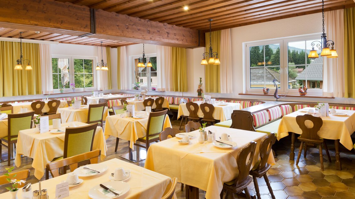 Ein gemütlicher Speisesaal mit Tischen und Stühlen. Die Fenster lassen viel Licht hereinfällen und die Dekoration ist hell und einladend. | © Hotel Seebacherhof_(c)Hagspiel