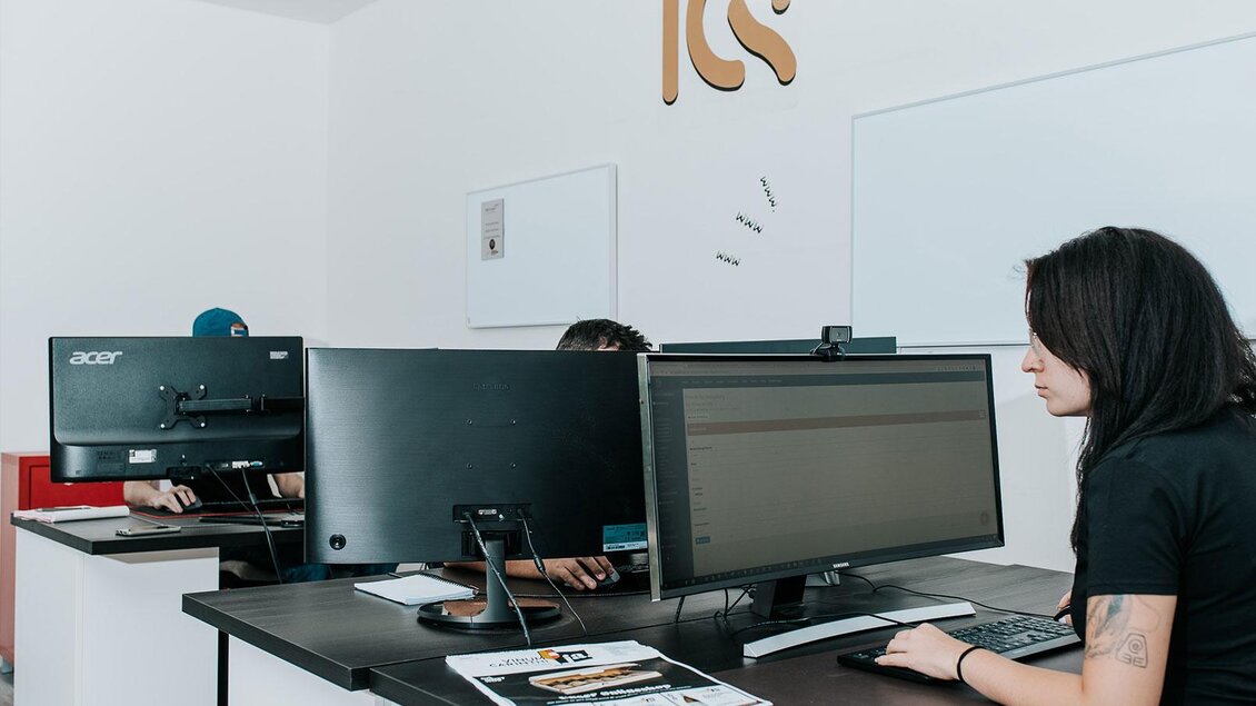 Ein modernes Büro mit mehreren Arbeitsplätzen. Zwei Personen sitzen an Computern und arbeiten konzentriert. | © (C) Qualtität Südststeiermark