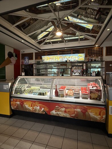 Ein gemütliches Eiscafé mit einem Präsentationsdisplay für Eiscreme. Die Inneneinrichtung ist freundlich und einladend. | © Taip Rastoder