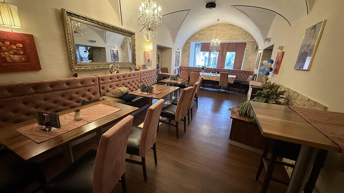 Ein gemütliches Restaurant mit eleganter Innenausstattung und gepolsterten Sitzbänken. Große Fenster sorgen für viel Tageslicht und eine einladende Atmosphäre. | © Taip Rastoder