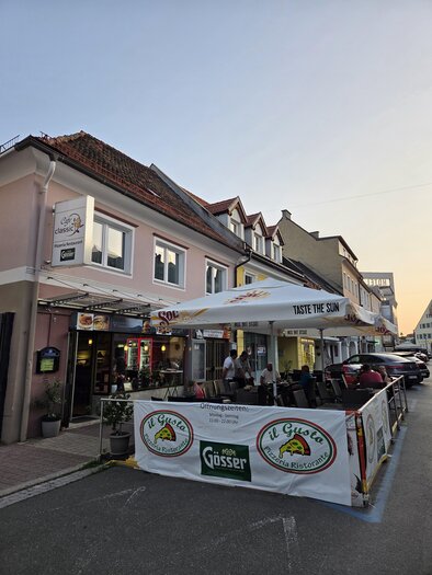Eine gemütliche Restaurantterrasse mit Sonnenschirmen und Tischen. Im Hintergrund sind farbige Häuser zu sehen, die eine einladende Atmosphäre schaffen. | © Il Gusto Classico
