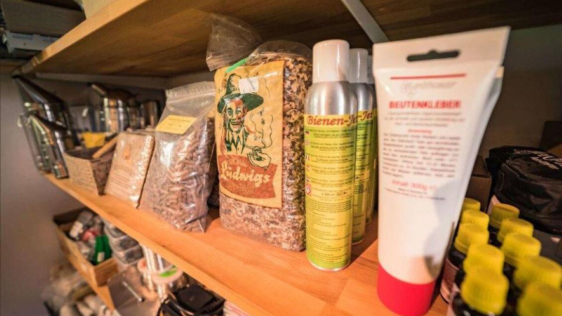 Ein Regal voller Vorräte und Produkte, darunter verschiedene Verpackungen und Flaschen. Die Farben sind vielfältig und die Anordnung wirkt organisiert. | © Imkerei Sonja Plank