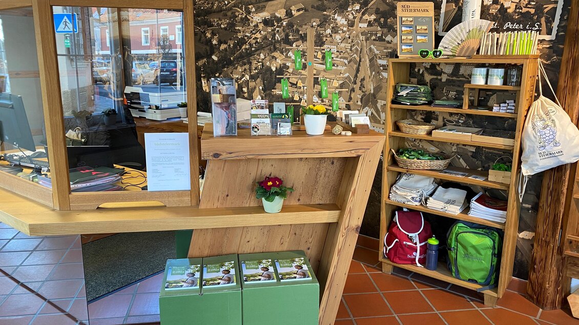 Ein freundlicher Empfangsbereich mit einem Holztresen und Regalen. Im Hintergrund sind Produkte aus der Region Südsteiermark zu sehen. | © TV Südsteiermark