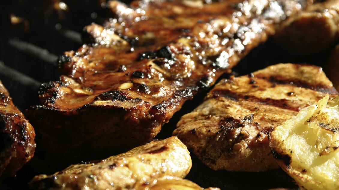 Gegrilltes Fleisch mit einer appetitlichen, karamellisierten Oberfläche und gegrillten Zwiebeln. Es sieht köstlich und einladend aus. | © LK Stmk
