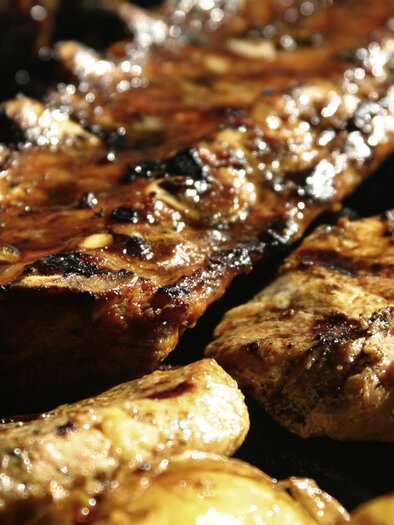 Grilled meat with an appetizing, caramelized surface and grilled onions. It looks delicious and inviting. | © LK Stmk