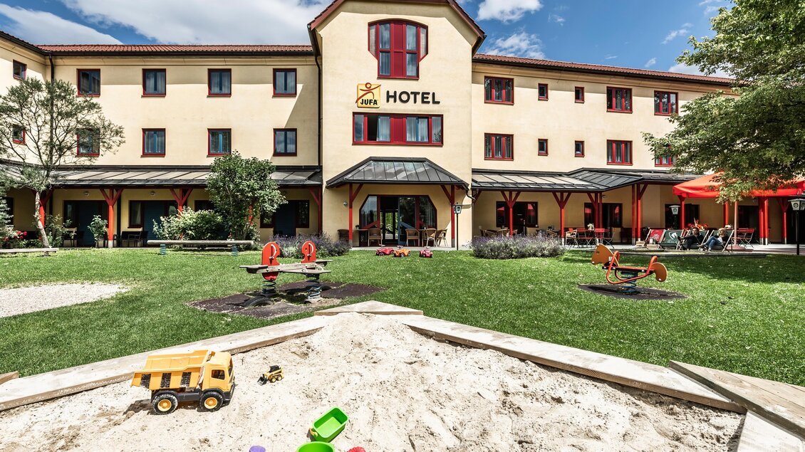 JUFA Hotel in Maria Lankowitz mit Terrasse, Garten und Spielplatz mit Sandkiste vor dem Gebäude. | © Lipizzanerheimat-Lenz