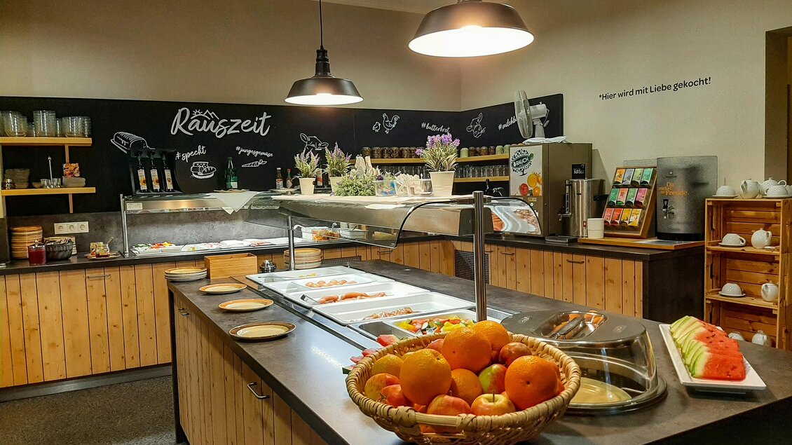 Buffet im JUFA Restaurant in Maria Lankowitz mit Obstschale, warmen Speisen, Getränkestation und Sitzbereich im Hintergrund.  | © Lipizzanerheimat-Lorenzoni